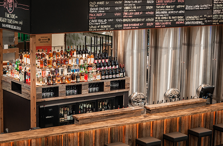 A wooden bar at Moon Dog Brewing stacked with alcohol.